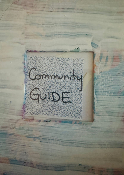 A photo album with a painted cover, labelled "Community Guide."